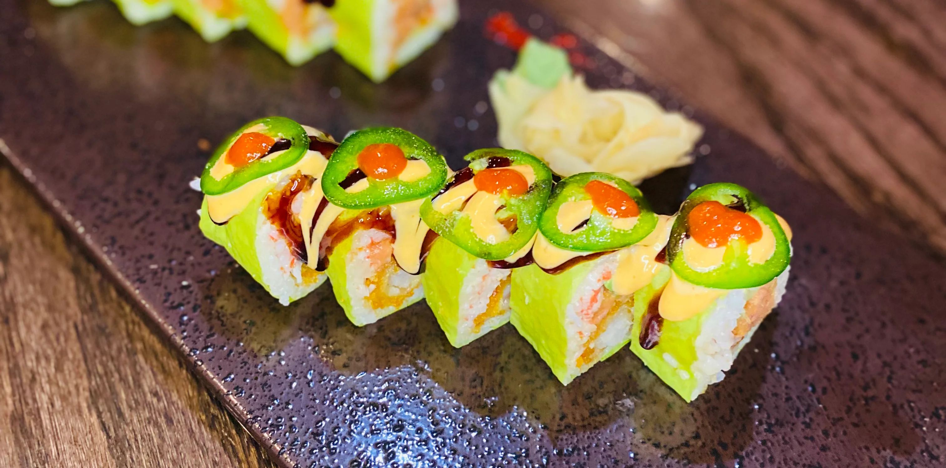 A beautifully arranged plate of sushi with various types and colors.