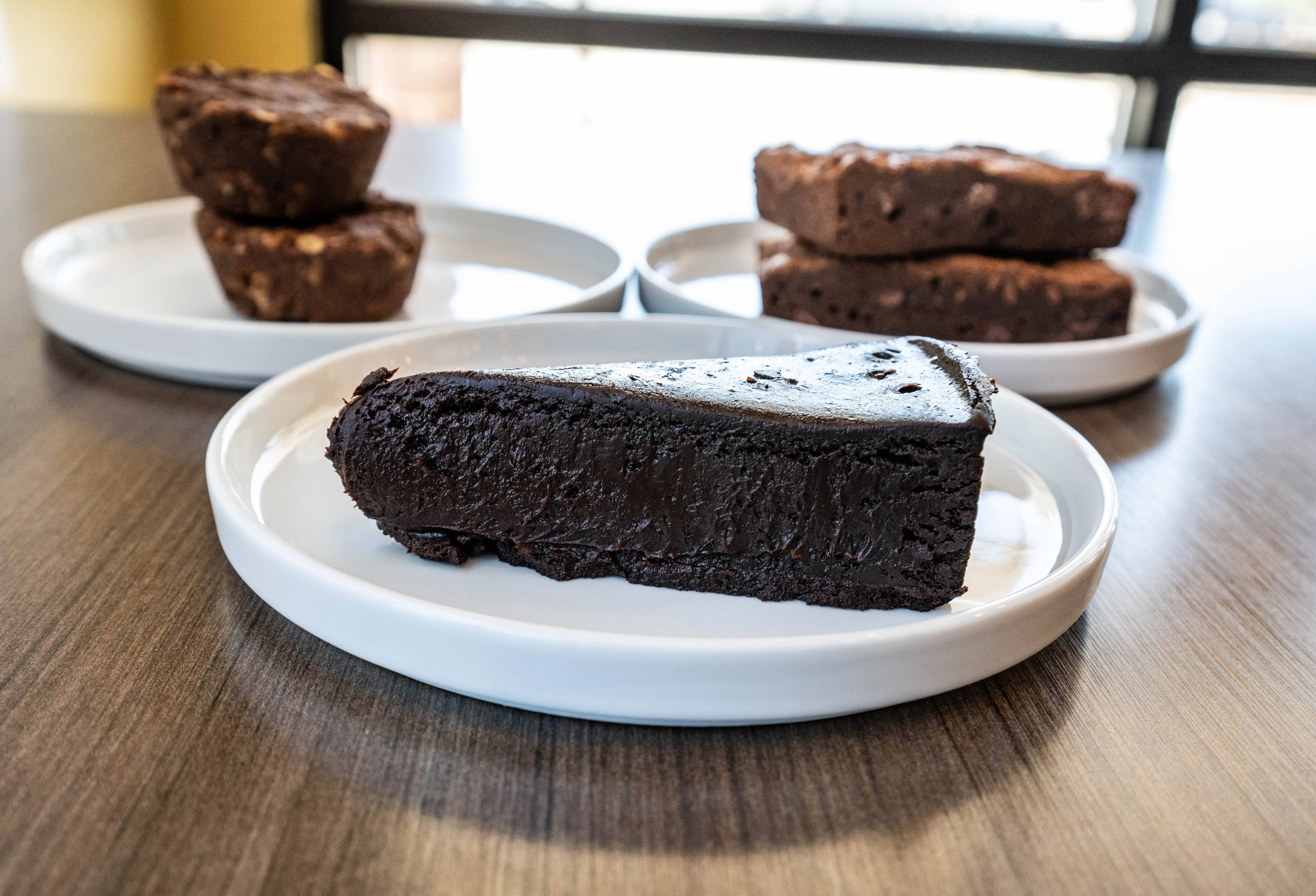Decadent chocolate fudge cake slice on a black plate