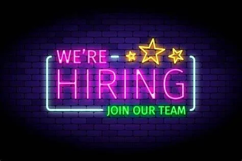 Neon sign announcing job openings in vibrant colors