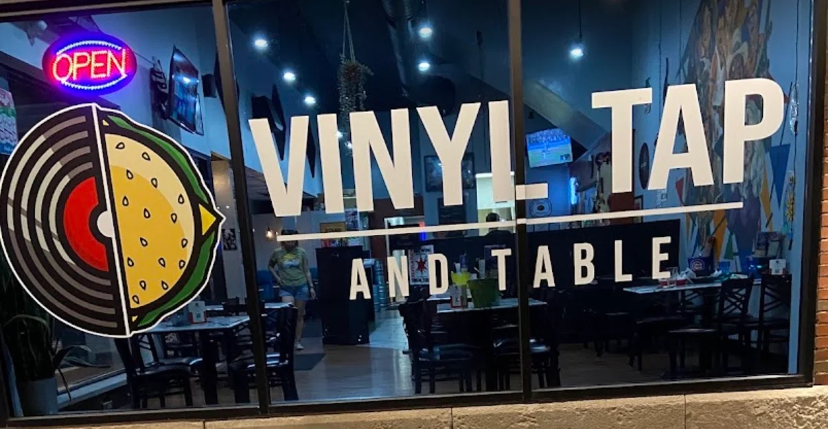 Exterior view of Vinyl Tap and Table restaurant with open sign.