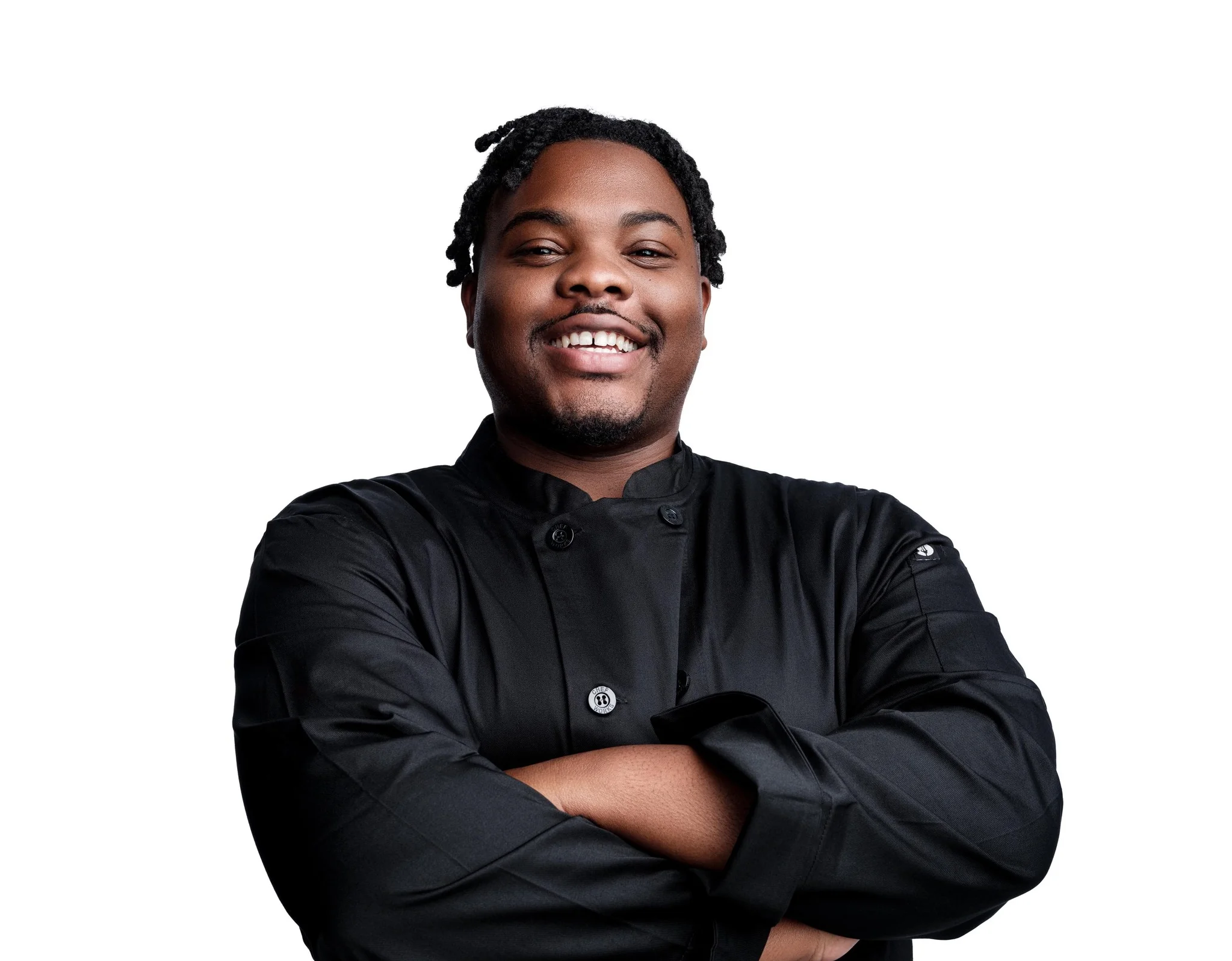 Chef in a black uniform smiling confidently