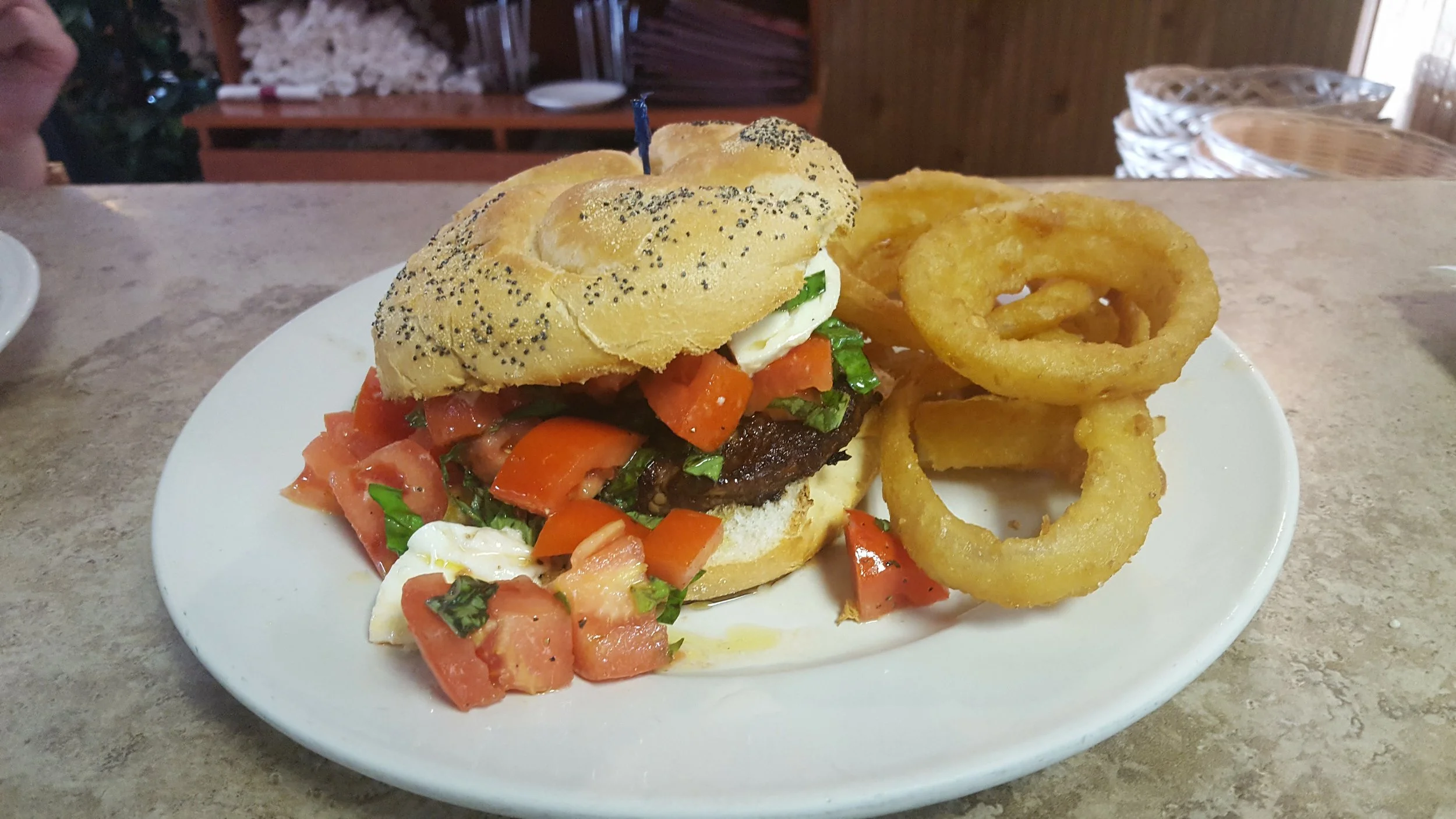 Juicy hamburger with fresh salsa and onion rings
