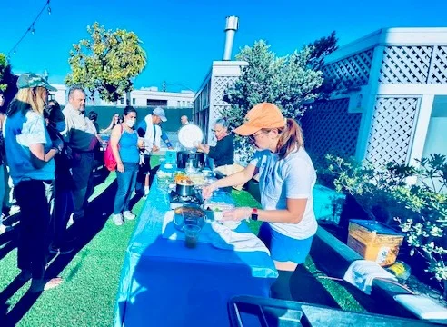 Outdoor cooking event with chefs and guests enjoying food