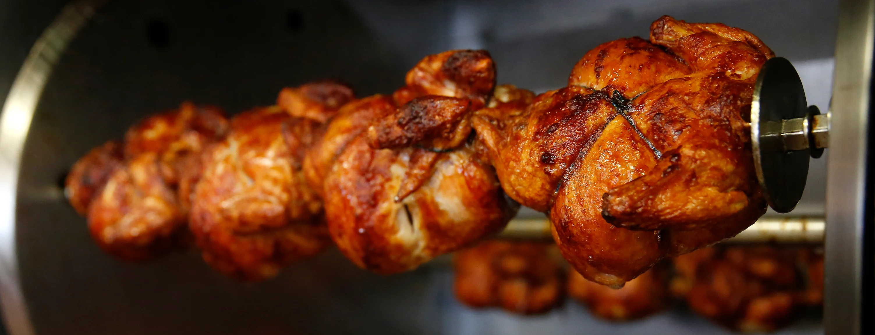 Rotisserie chicken cooking on a spit