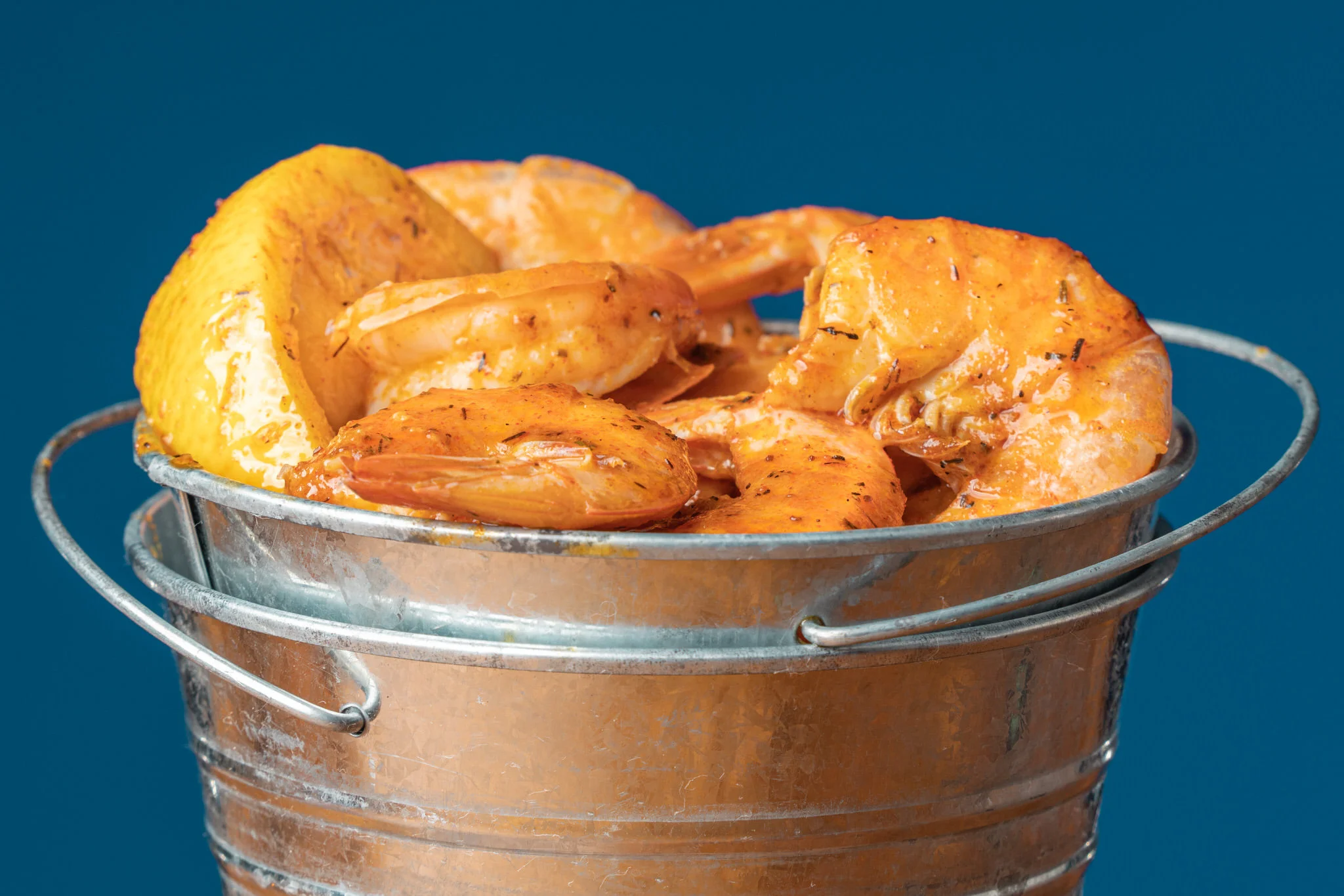 Spicy shrimp boil served in a metal bucket