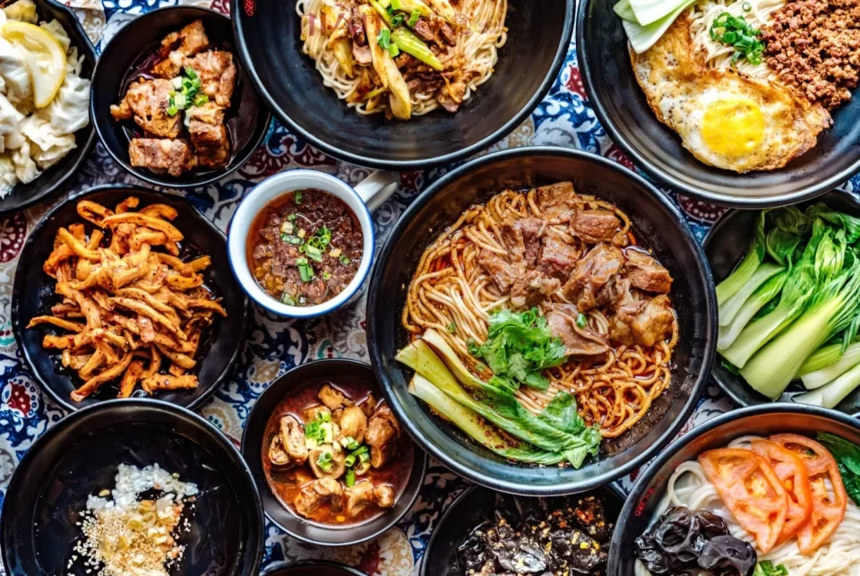 Assorted Chinese noodle dishes with vegetables and meats