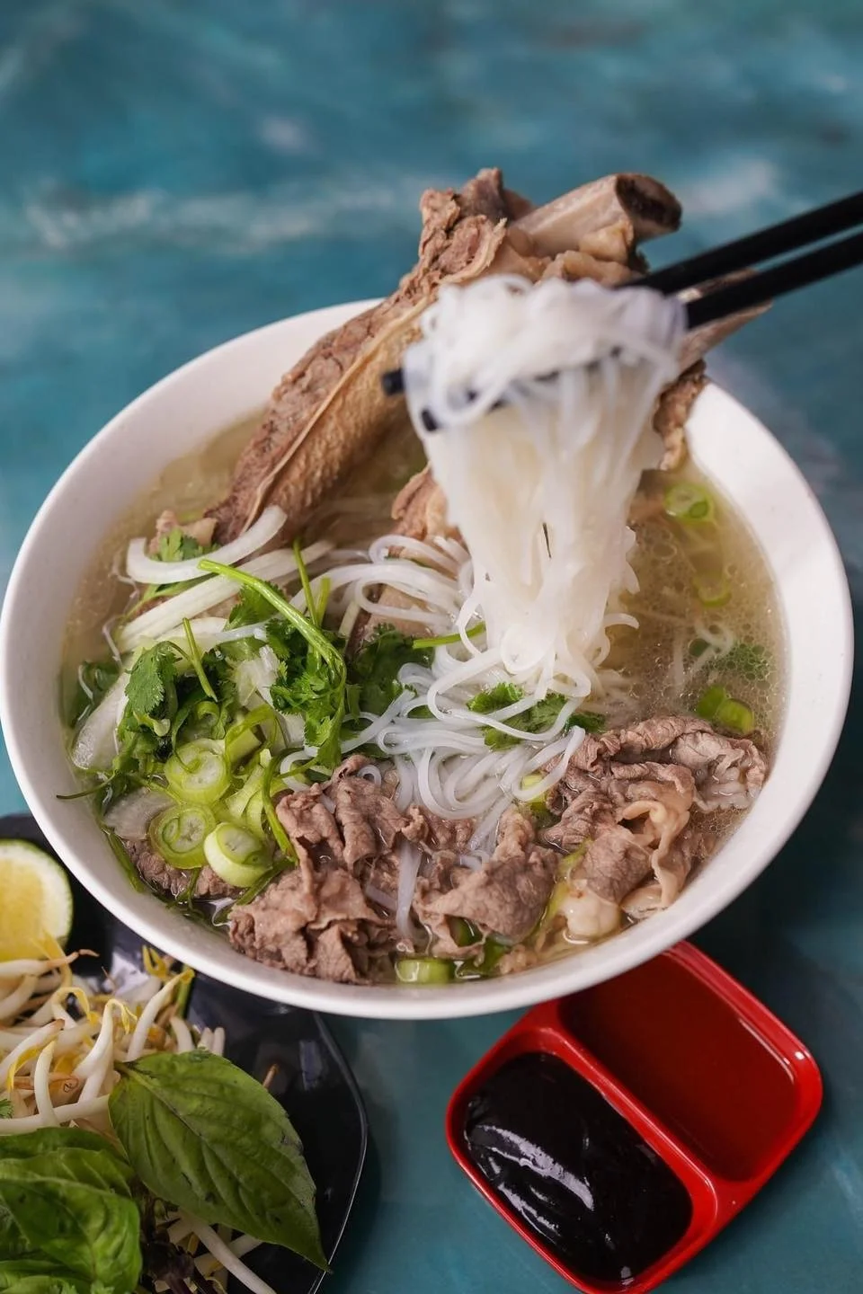 Bowl of Vietnamese pho with beef and fresh herbs