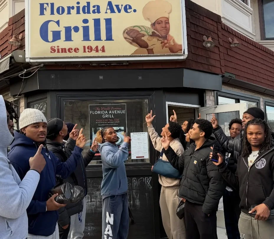 Group outside Florida Avenue Grill restaurant beneath vintage exterior signage