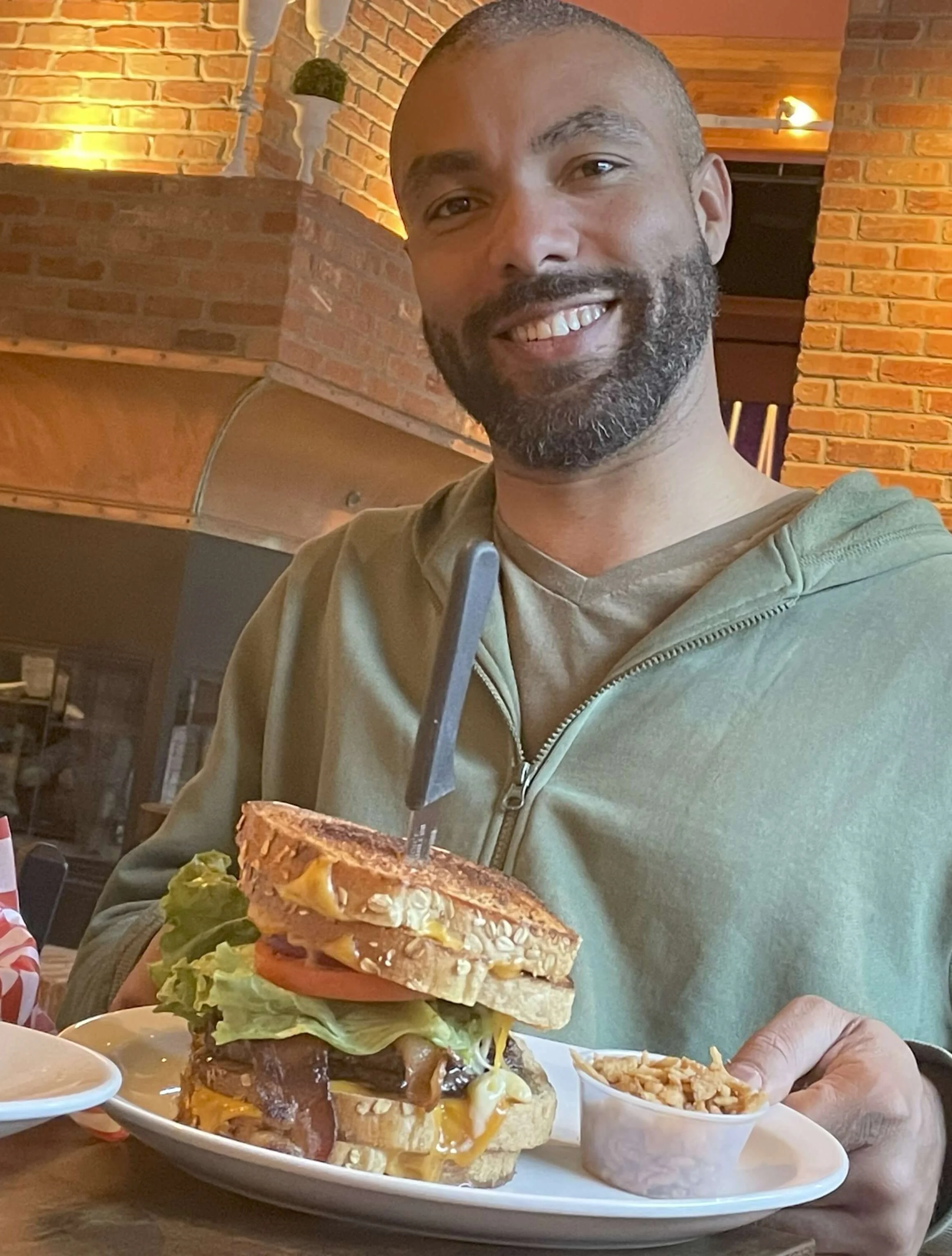 Gourmet cheeseburger with lettuce and tomato in a cozy restaurant setting