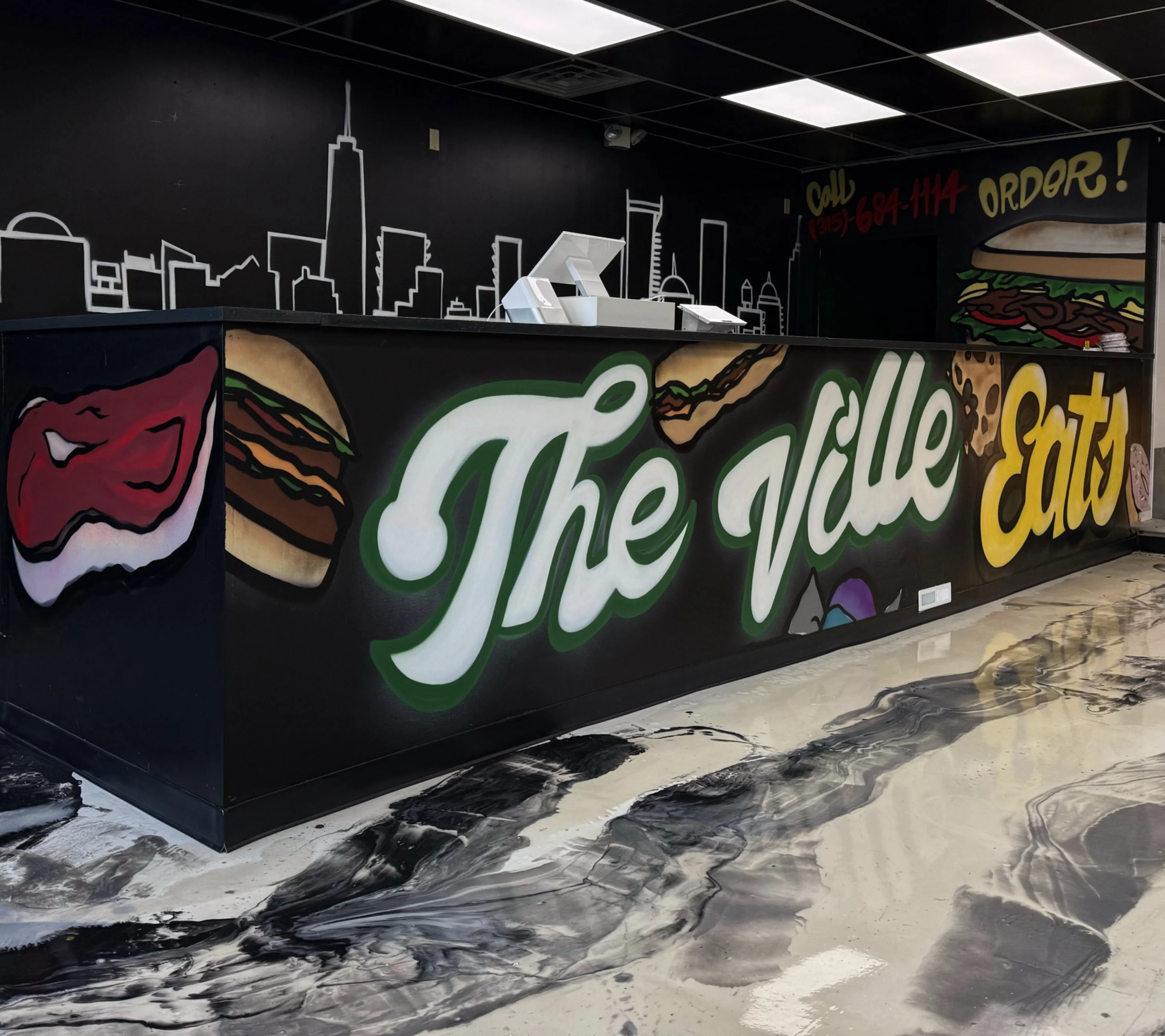 Modern restaurant counter with vibrant mural and city skyline design