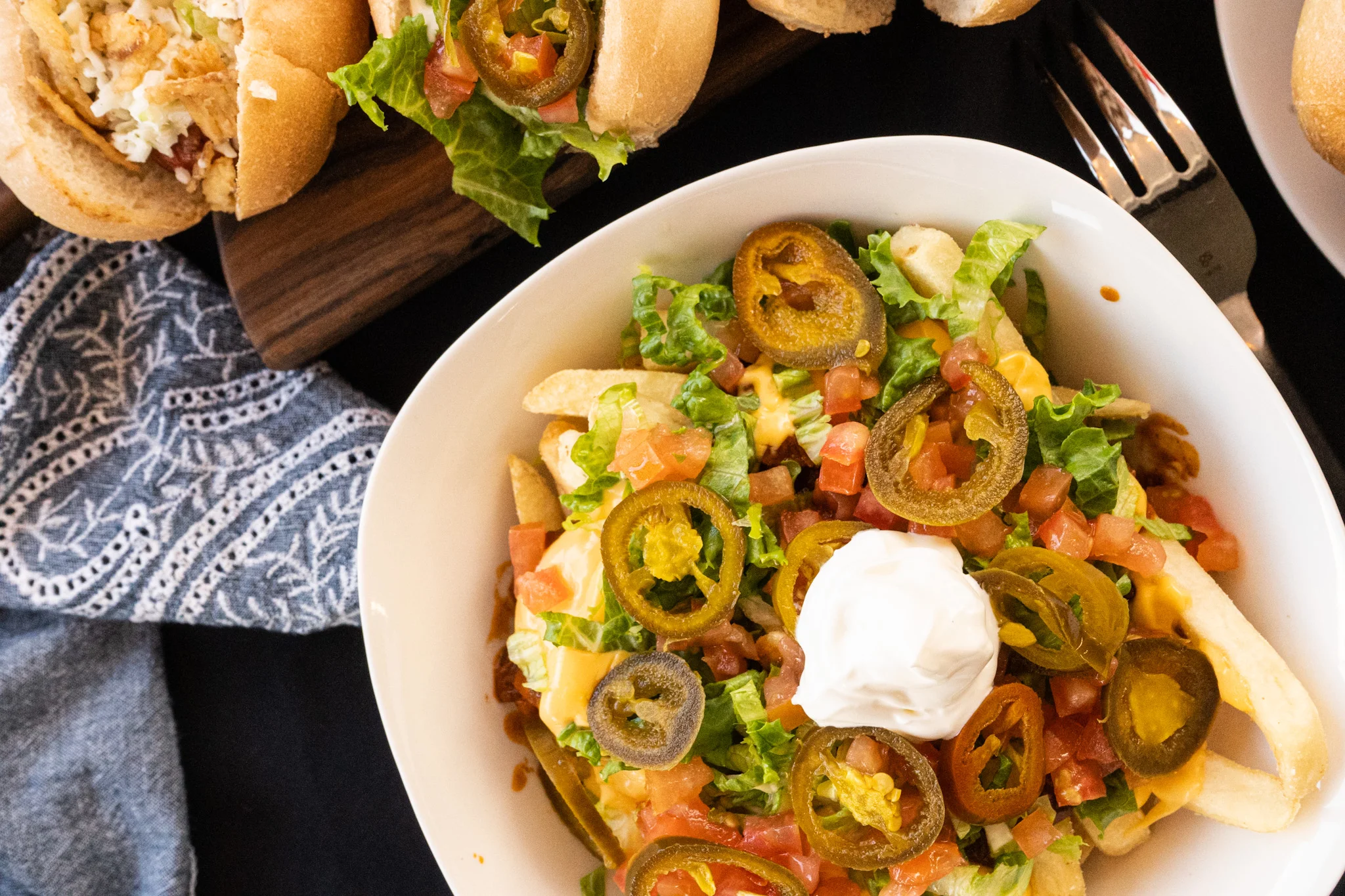 Loaded nachos topped with jalapeños and sour cream