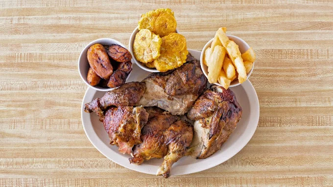 Grilled chicken with plantains, tostones, and fries on a plate.