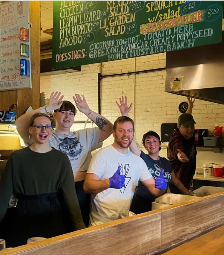 Friendly restaurant staff posing in a cozy eatery