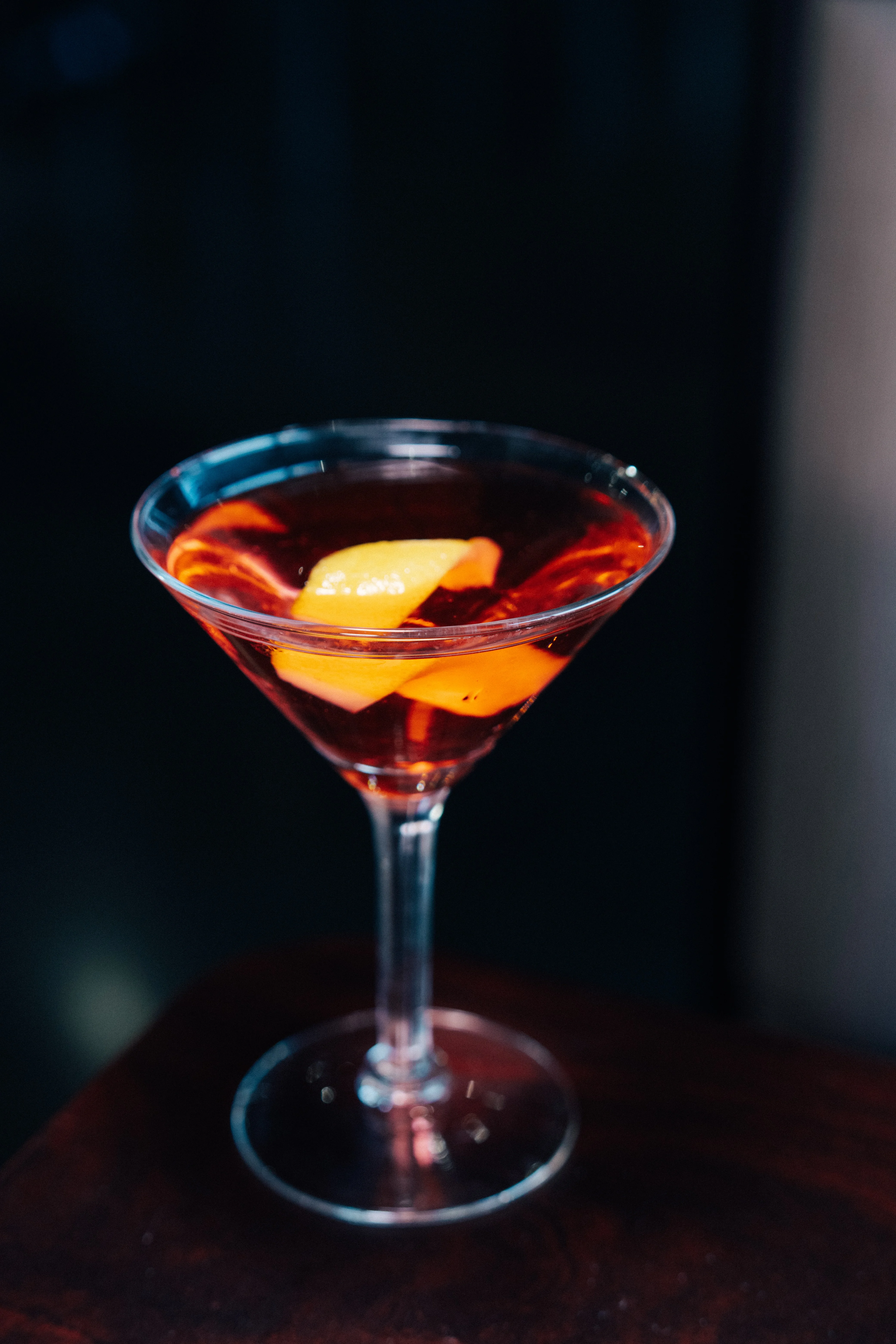Classic cocktail with orange garnish in a martini glass
