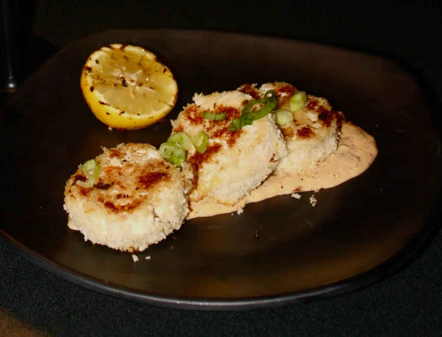 Crispy crab cakes with spicy sauce and grilled lemon