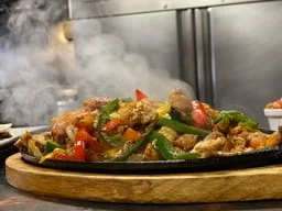 Sizzling fajitas served on a hot skillet