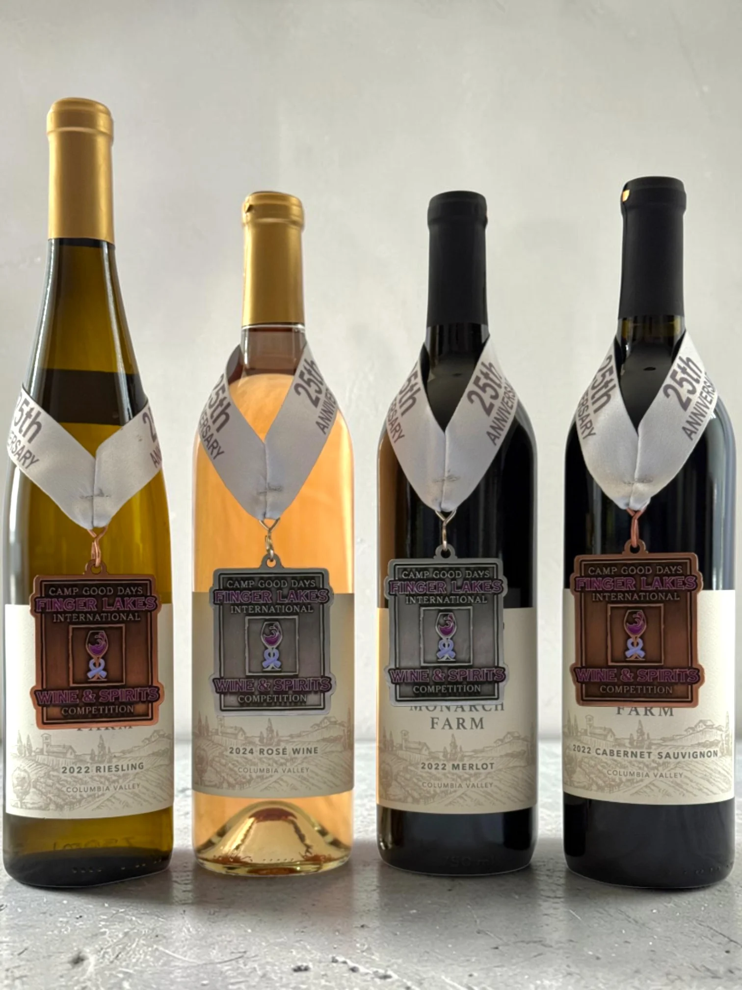 Four Monarch Farm wine bottles displaying Finger Lakes International Wine Competition award medals