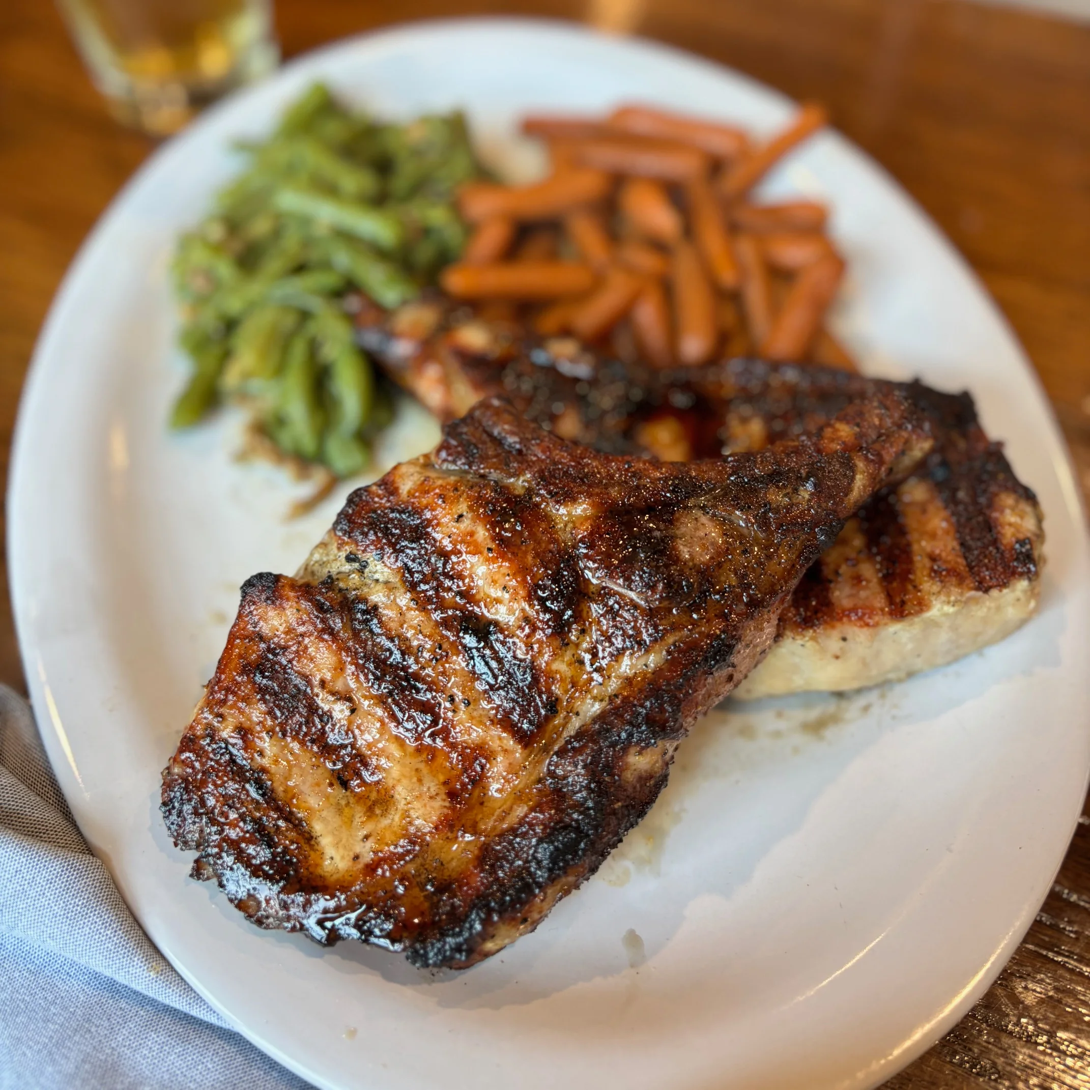 Grilled chicken breast with sides in a rustic restaurant setting