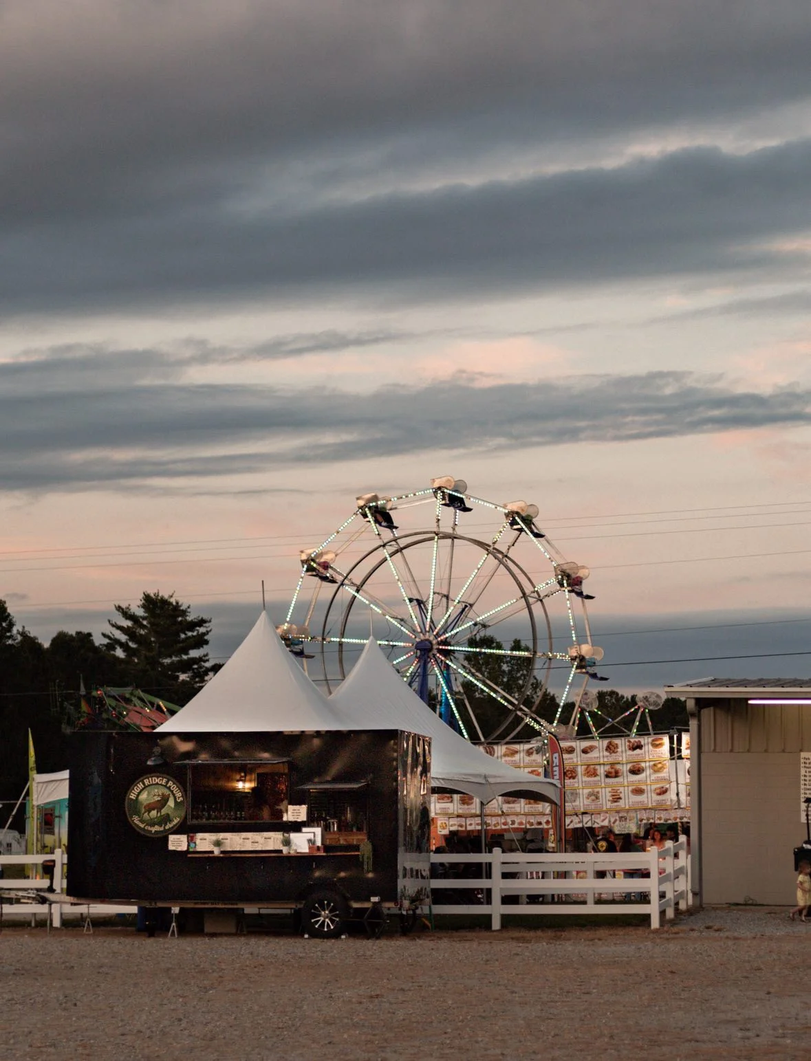 Food truck at a fair with a ferris wheel in the background
