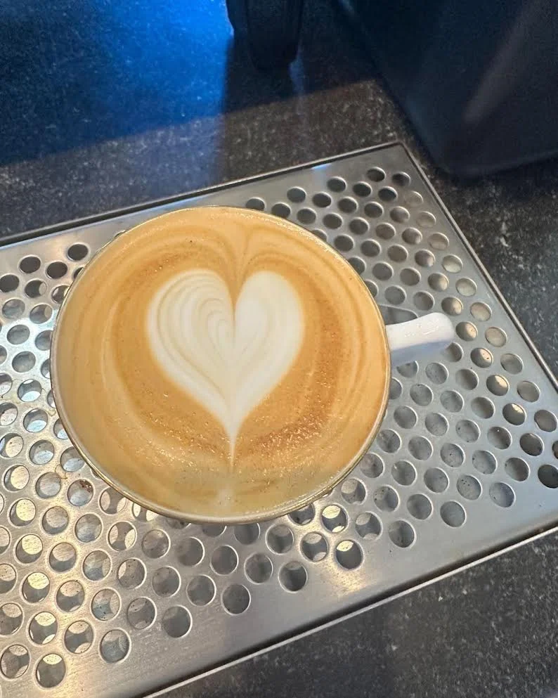Heart-shaped latte art in a white cup