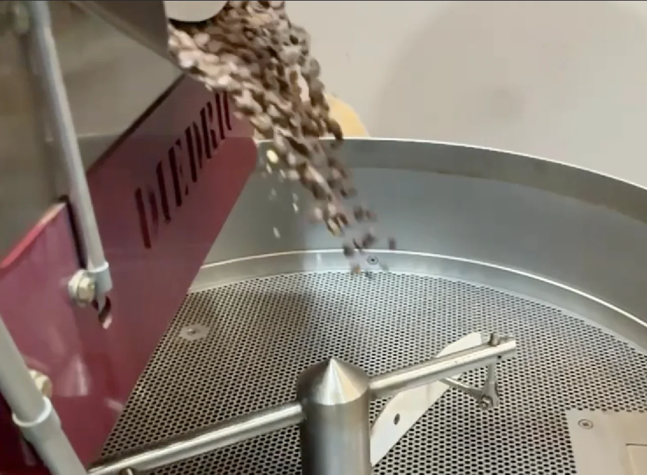 Freshly roasted coffee beans pouring from a roaster