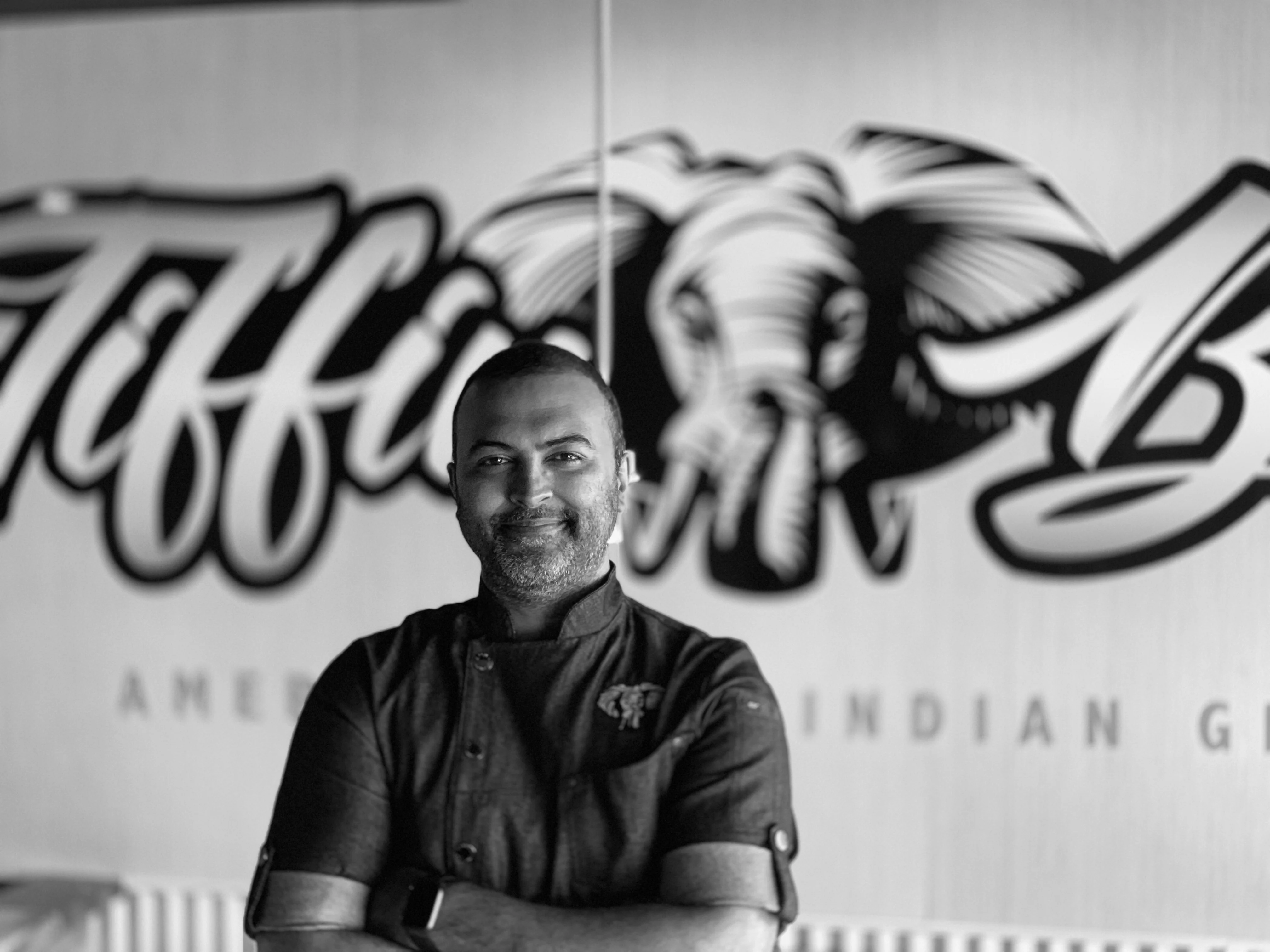 The Owner of Tiffin Box standing behind the counter of his restaurant