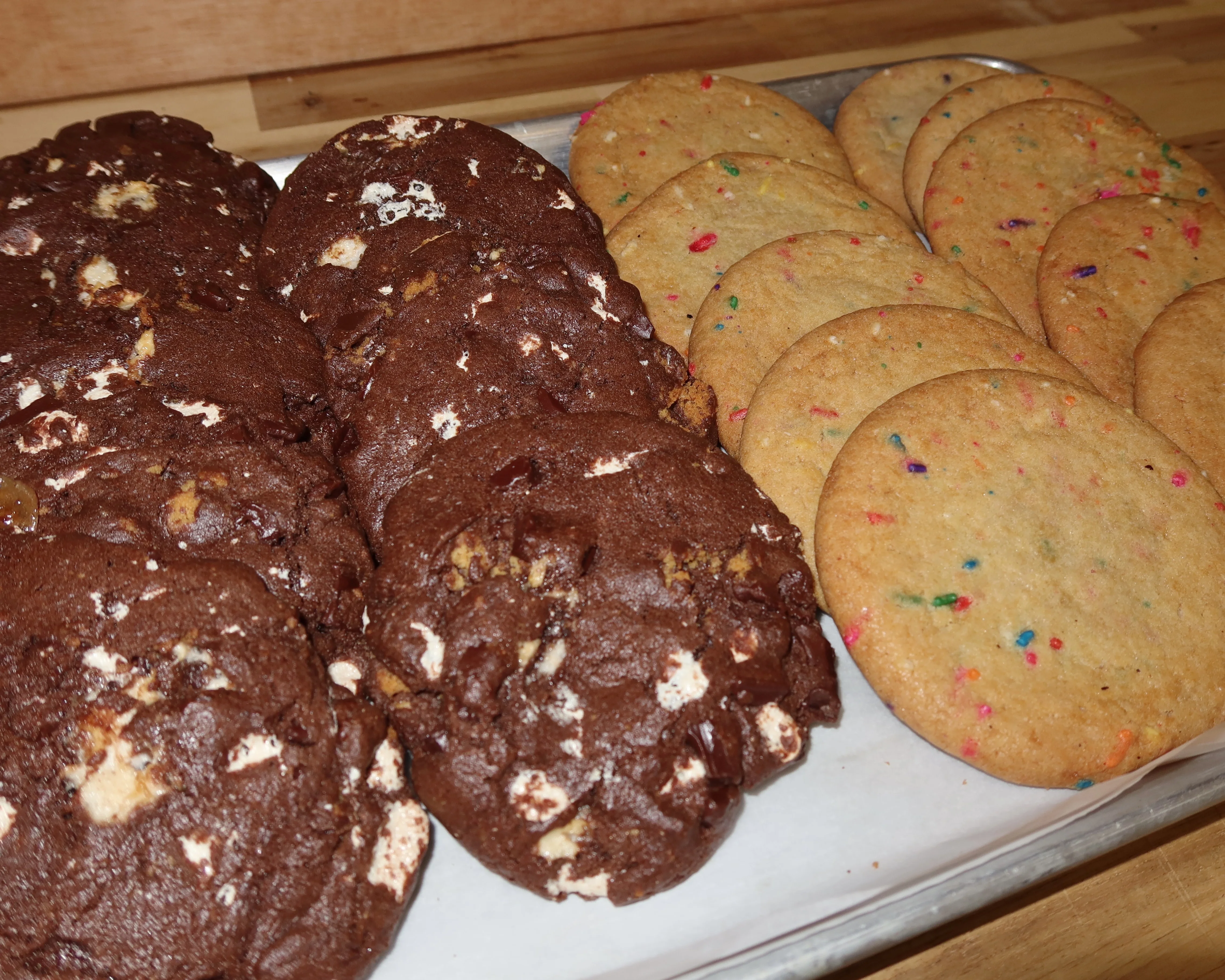 Freshly baked chocolate and funfetti cookies on a tray