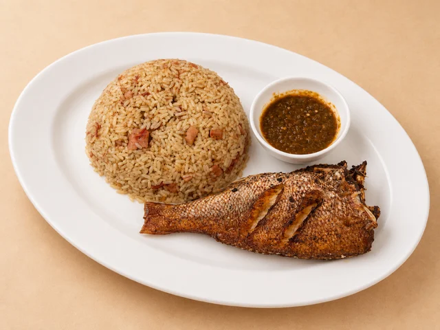 A platter of seasoned rice accompanied by a grilled fish and a small bowl of sauce.