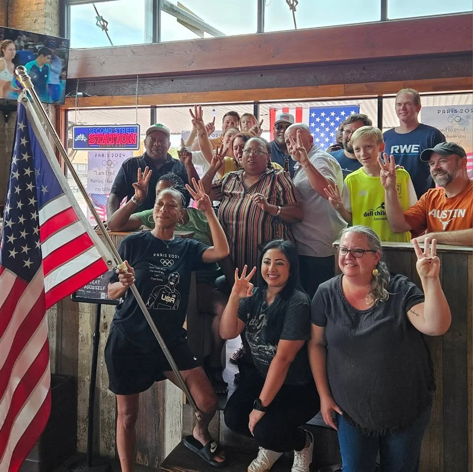 Group celebration at a restaurant with American flags and Olympic spirit