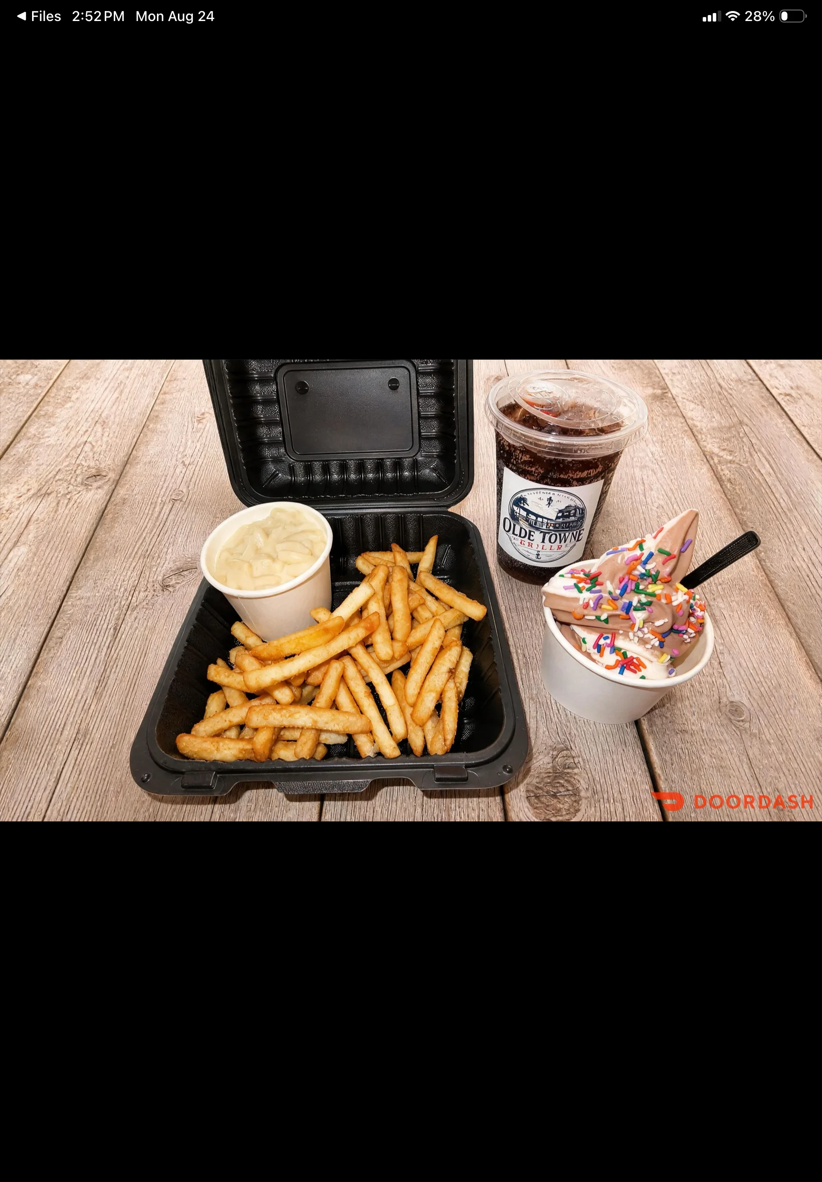 Takeout box with French fries, mac and cheese, and soft serve ice cream