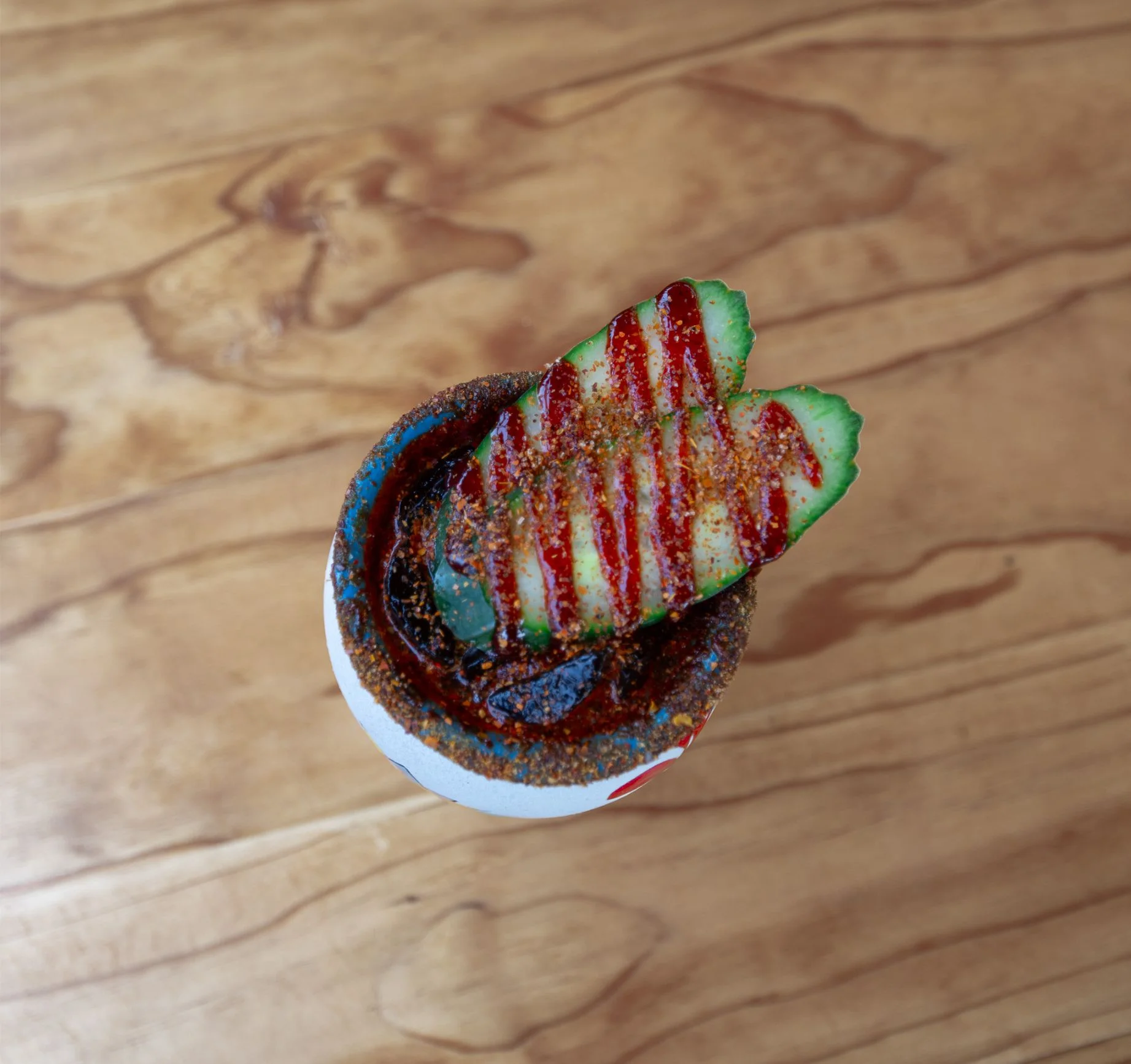 Spicy Mexican michelada garnished with cucumber slices