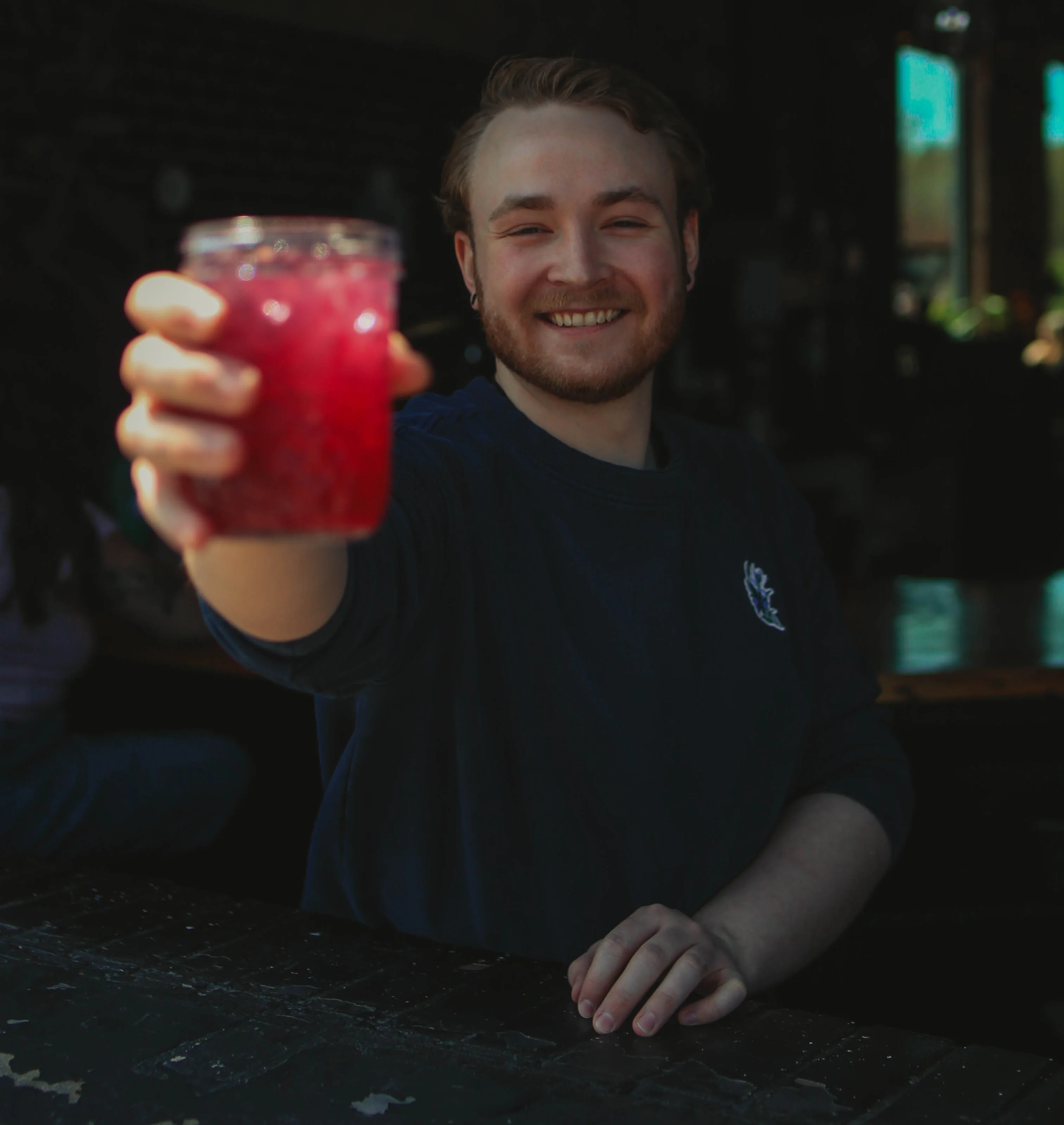 Bartender serving a vibrant cocktail at a trendy bar