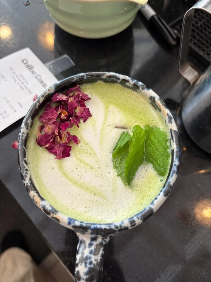 Matcha latte with rose petals and mint garnish