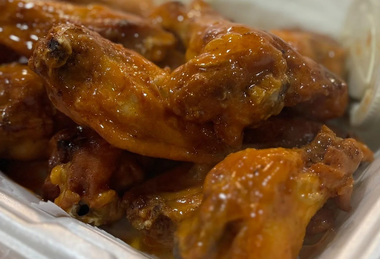 Spicy buffalo chicken wings served in a takeout container