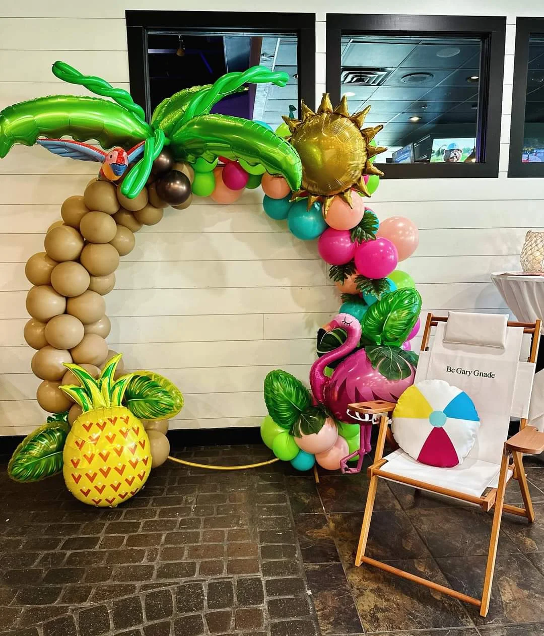Colorful balloon arch with tropical theme decorations