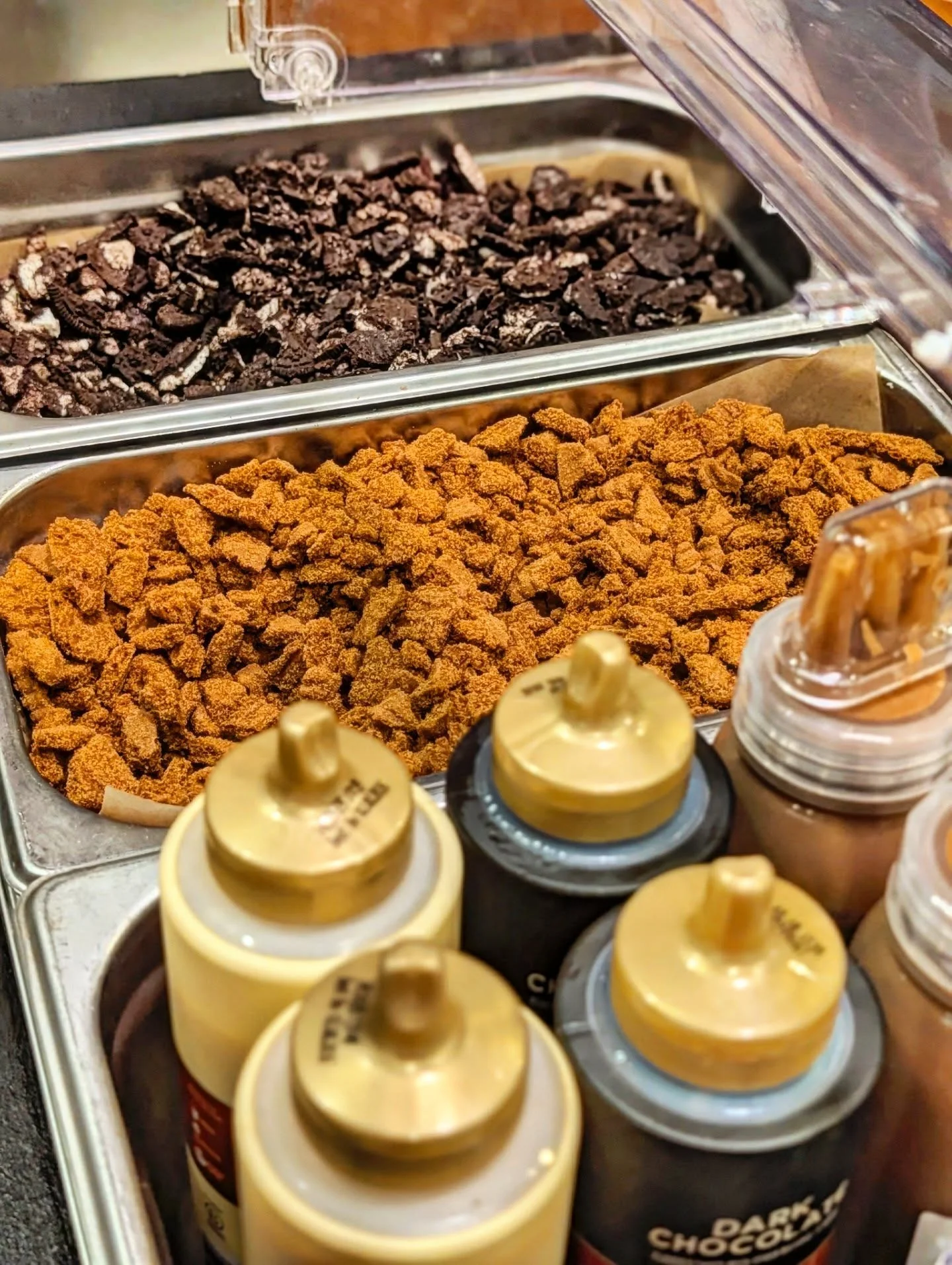 Toppings for desserts including crushed cookies and syrups