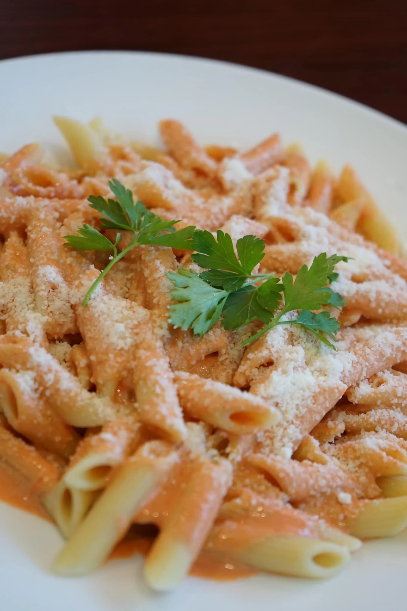 Creamy penne alla vodka topped with parmesan and parsley