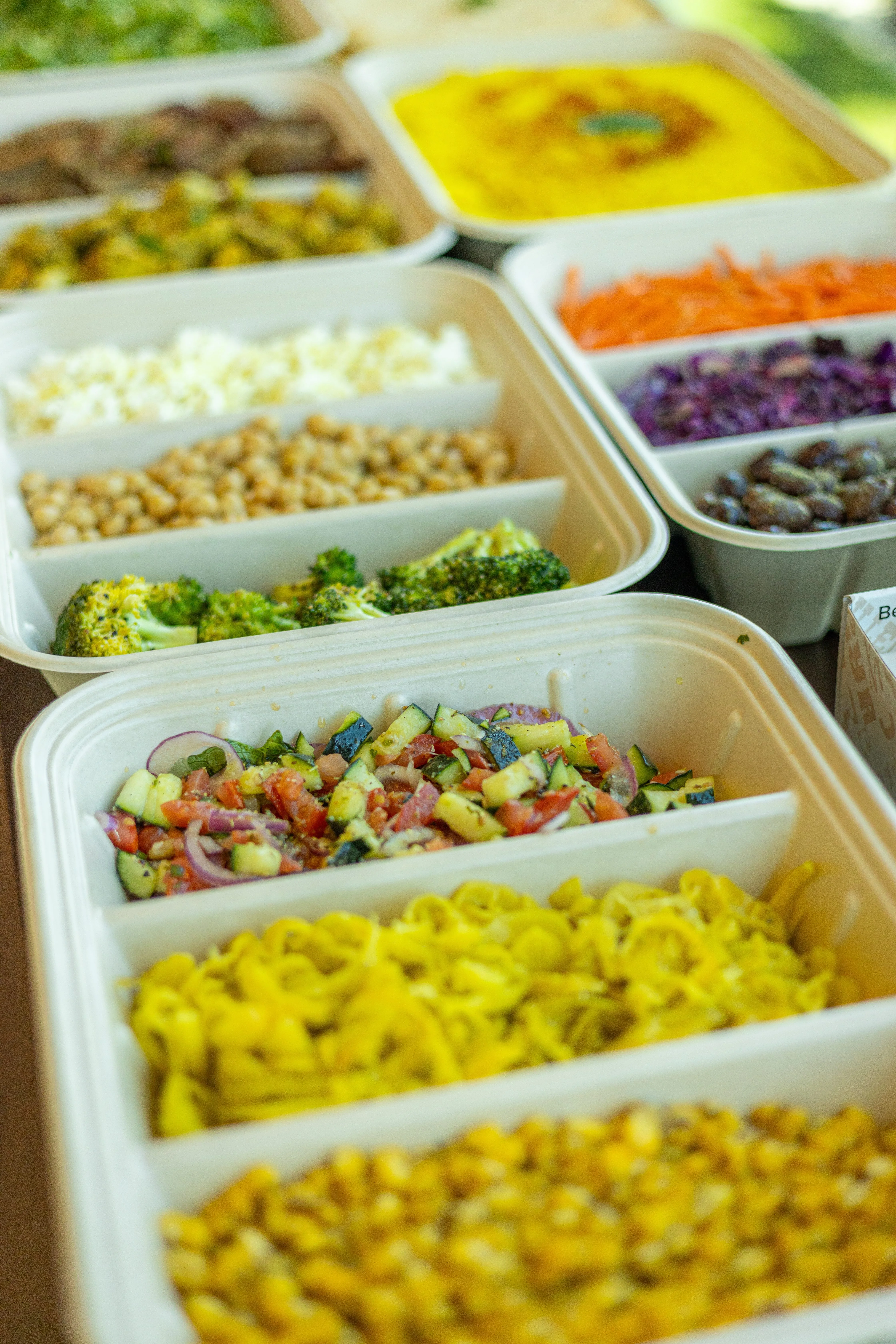 Santorini's catering spread with Mediterranean sides including chickpeas, broccoli, and fresh salads