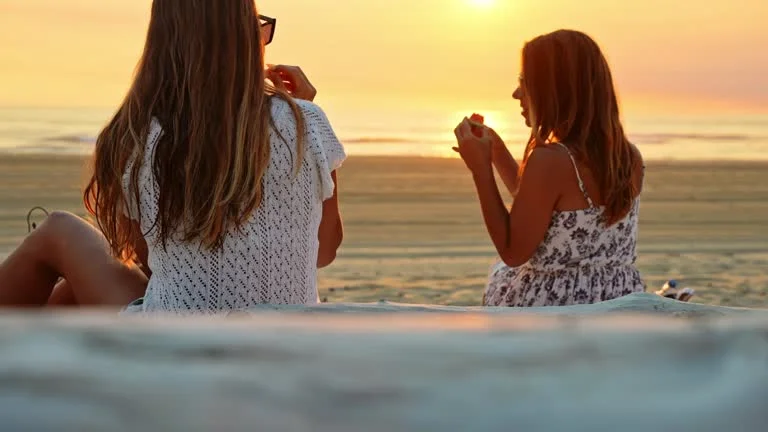 Two friends enjoying sunset on the beach