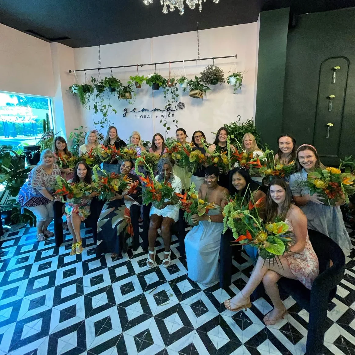 Group of women holding floral arrangements in a vibrant floral studio