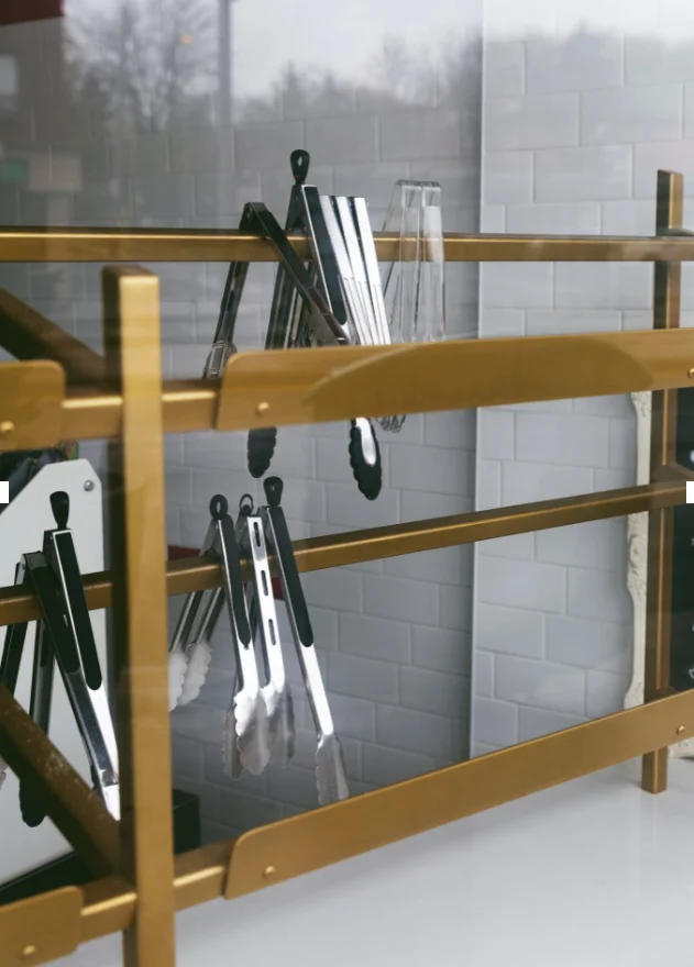 Cooking utensils on rack in kitchen at Tolex African Grill
