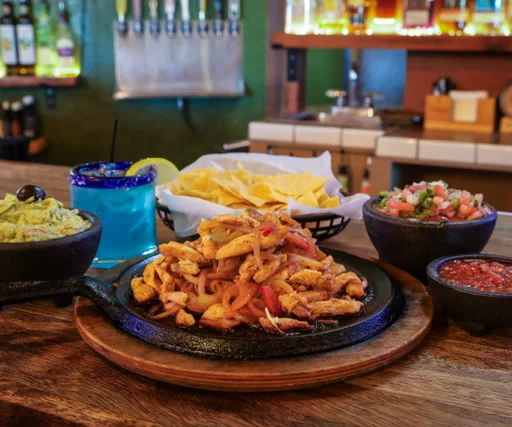 Sizzling chicken fajitas served with guacamole and chips