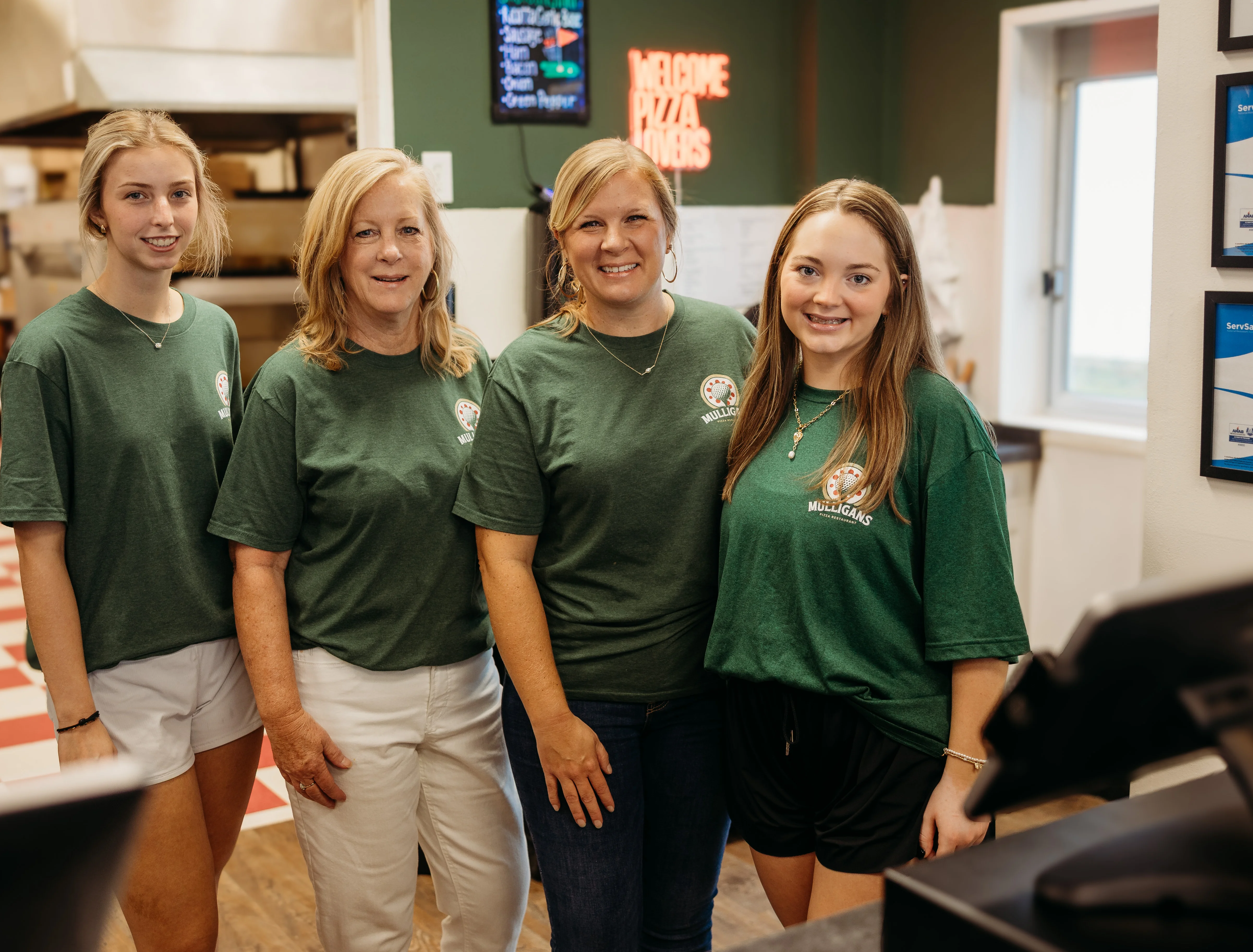 Friendly staff at a pizza restaurant welcoming customers