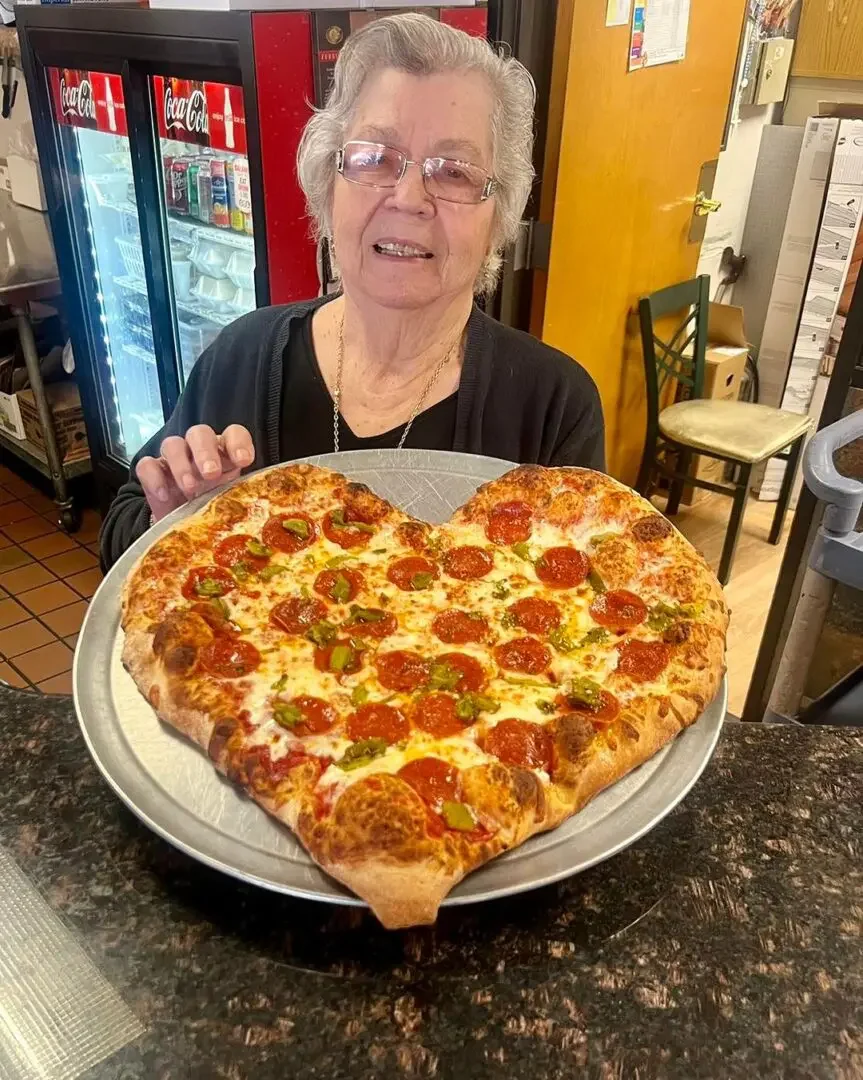 Heart-shaped pepperoni pizza in a cozy restaurant