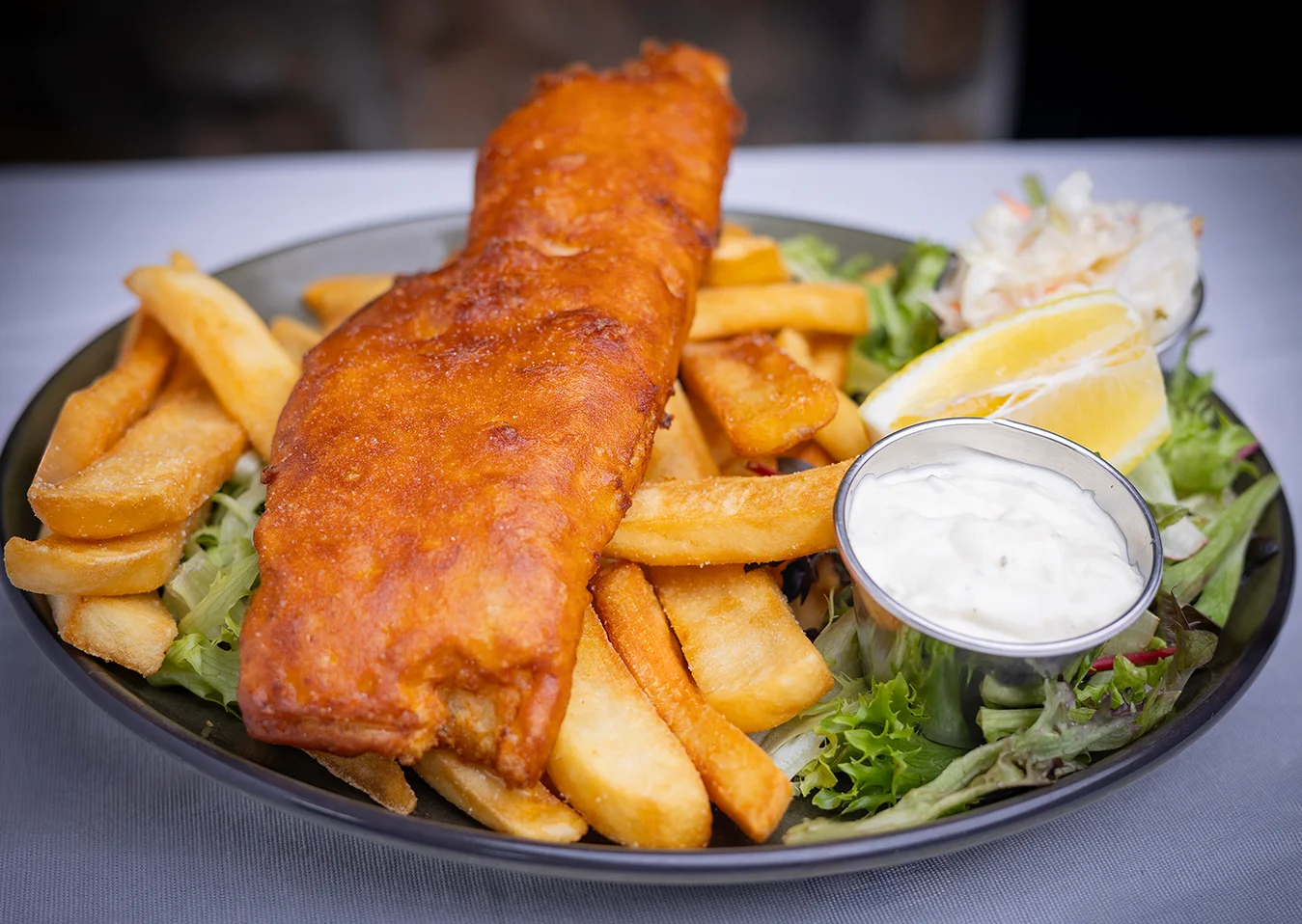 Classic British fish and chips served with tartar sauce and lemon