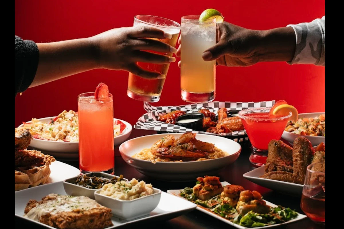 Cheers with cocktails and Southern comfort food spread on a table
