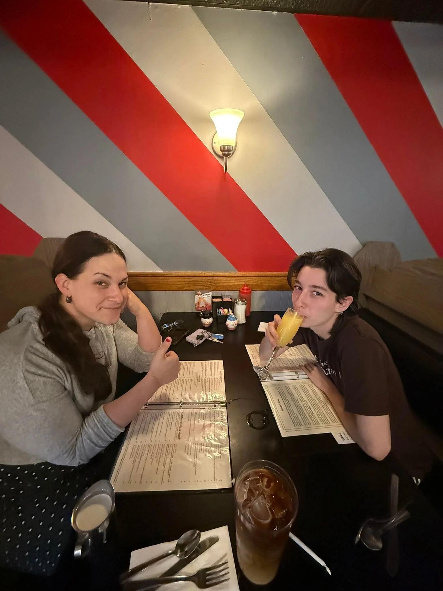 Two friends enjoying drinks at a cozy restaurant table