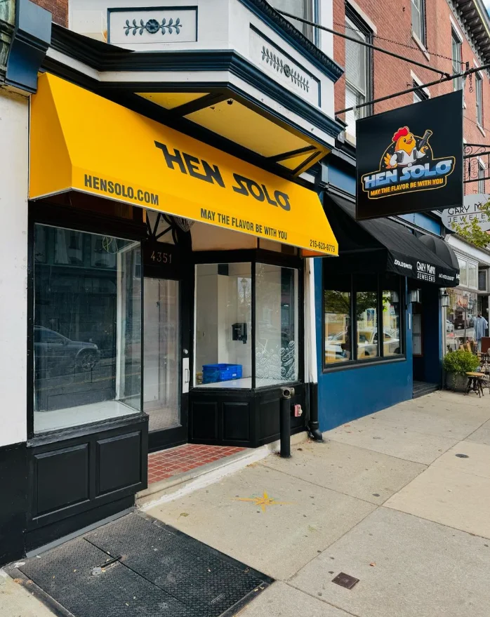 Exterior of Hen Solo restaurant with yellow awning and signage