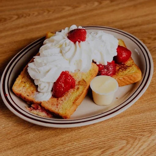Delicious French toast topped with whipped cream and strawberries