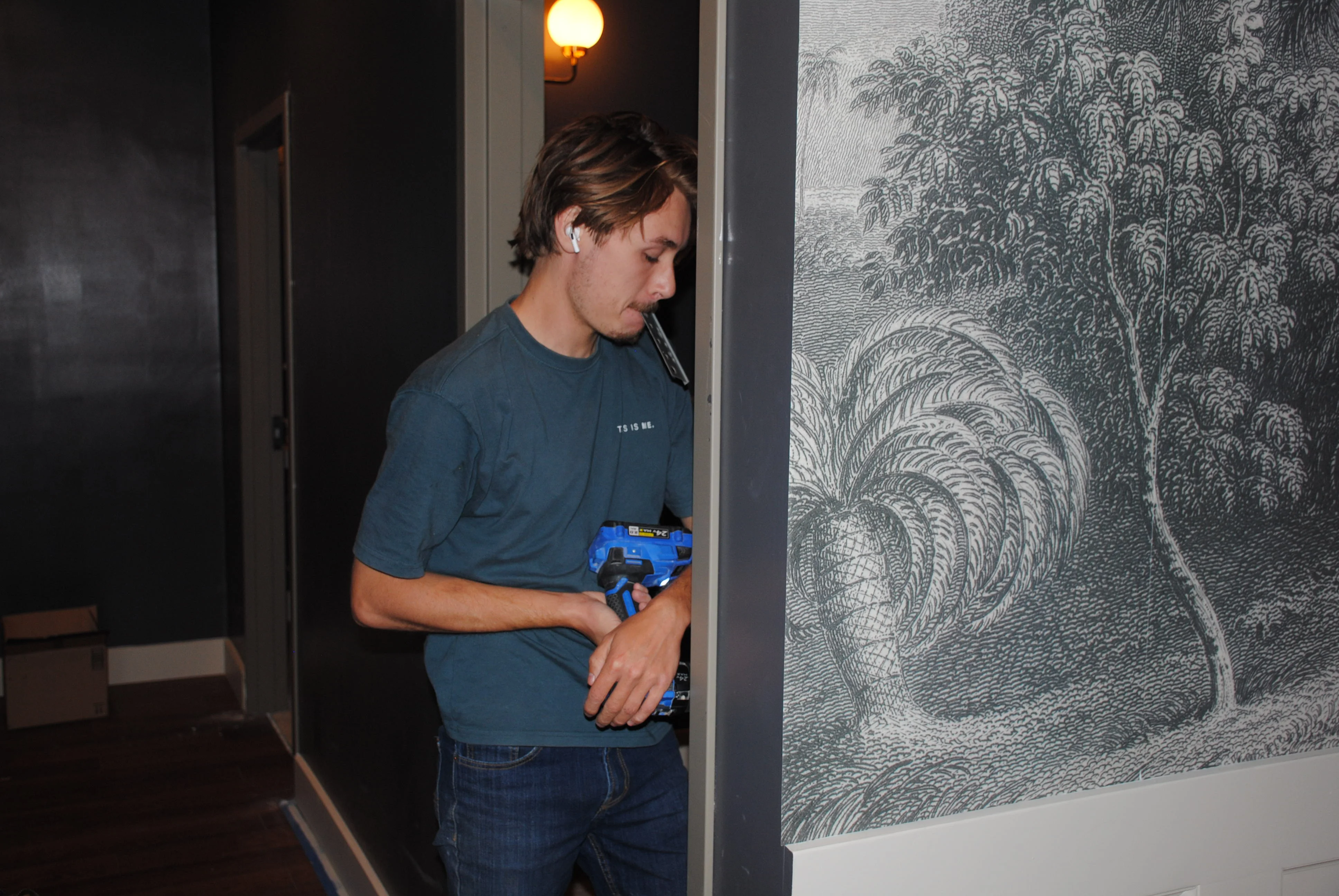 Person holding a cordless drill in a patterned restaurant interior